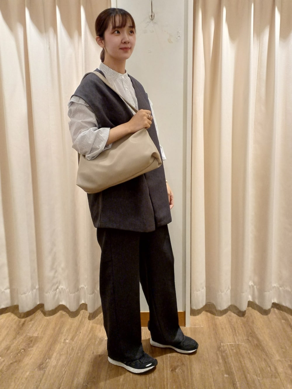 ホワイト系のショルダーバッグ、グレー系のベスト、グレー系のその他パンツを着用したレディースの秋コーディネートの3枚目の写真