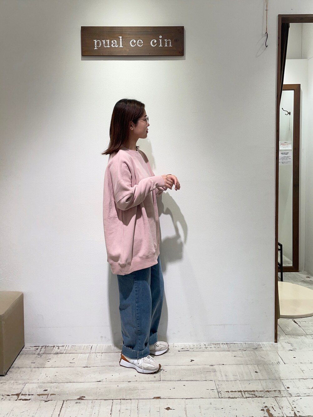 ピンク系のスウェット、ブルー系のデニムパンツを着用したレディースの秋コーディネートの3枚目の写真