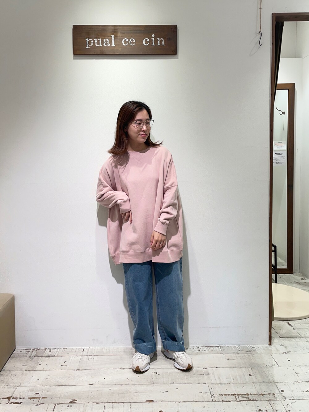 ピンク系のスウェット、ブルー系のデニムパンツを着用したレディースの秋コーディネートの2枚目の写真