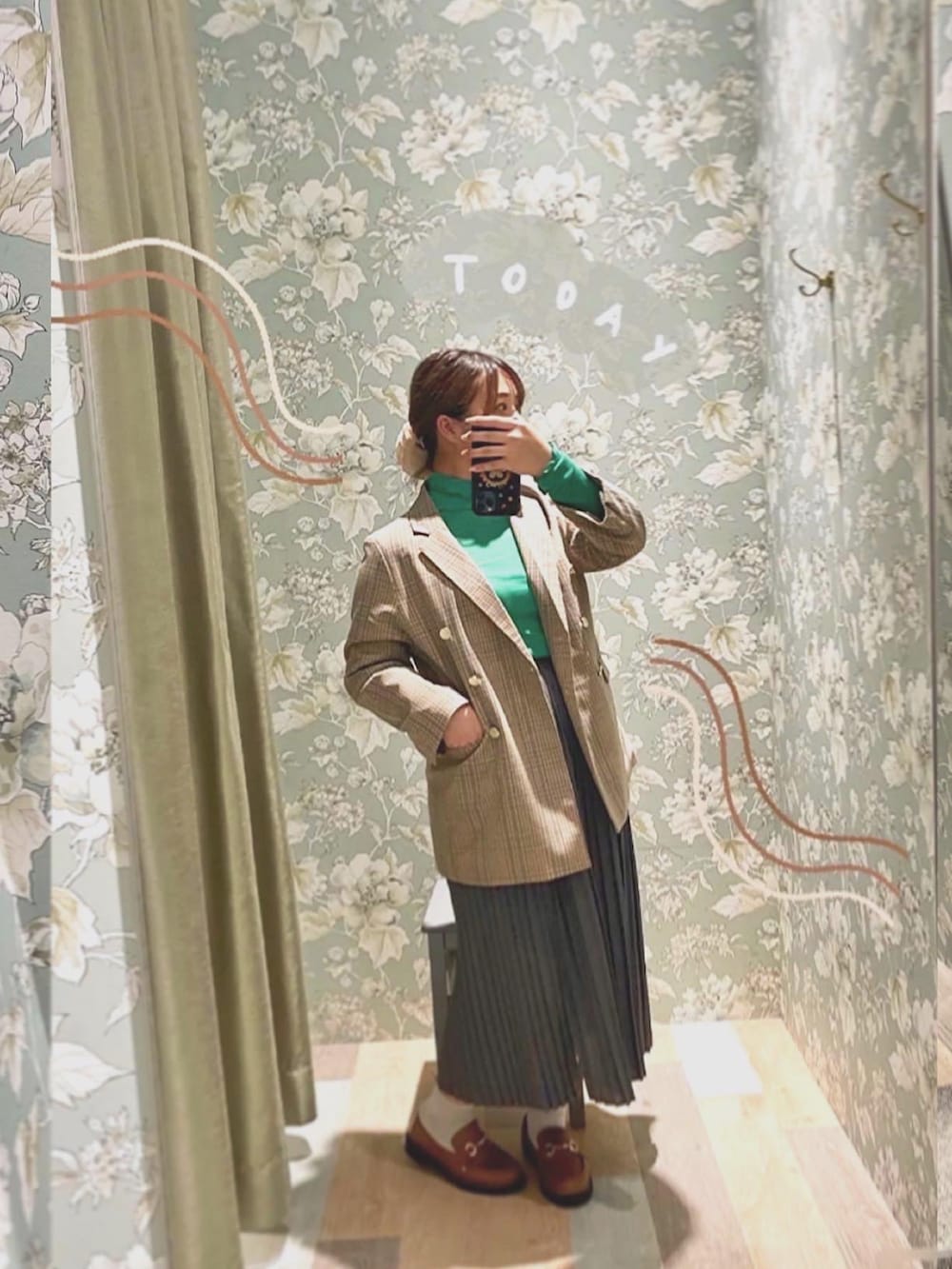 グリーン系のその他トップス、ブラウン系のテーラードジャケット、グレー系のスカートを着用したレディースの秋コーディネートの2枚目の写真