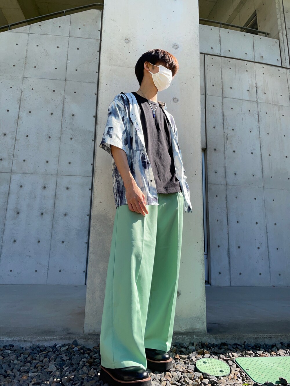 グリーン系のスラックス、ブラック系のTシャツ/カットソー、ホワイト系のシャツ/ブラウスを着用したメンズの夏コーディネートの2枚目の写真