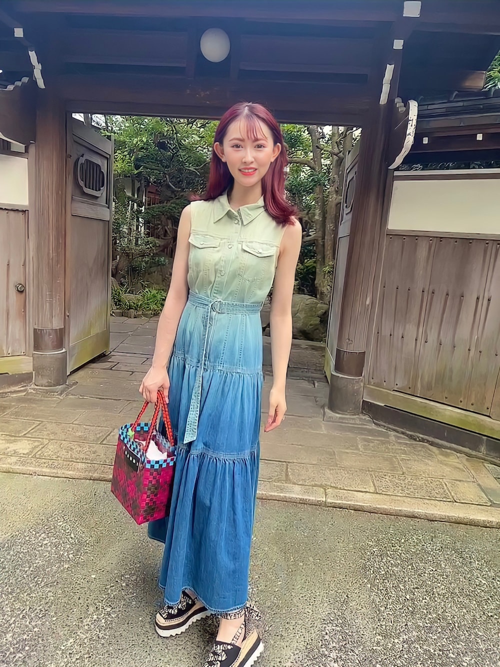 ブルー系のワンピース、レッド系のかごバッグ、ブラック系のサンダルを着用したレディースの夏コーディネートの2枚目の写真