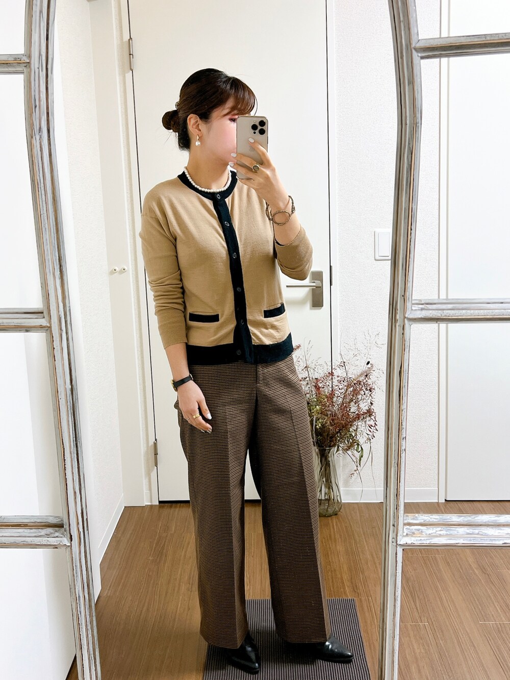 ベージュ系のカーディガン/ボレロ、ブラック系のハンドバッグ、ブラウン系のパンツを着用したレディースの冬コーディネートの2枚目の写真