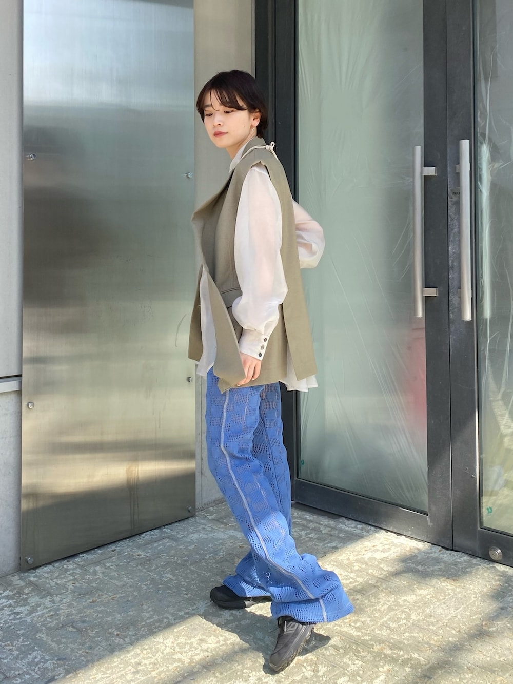 ホワイト系のシャツ/ブラウス、ブルー系のその他パンツ、グリーン系のベストを着用したレディースの春コーディネートの2枚目の写真