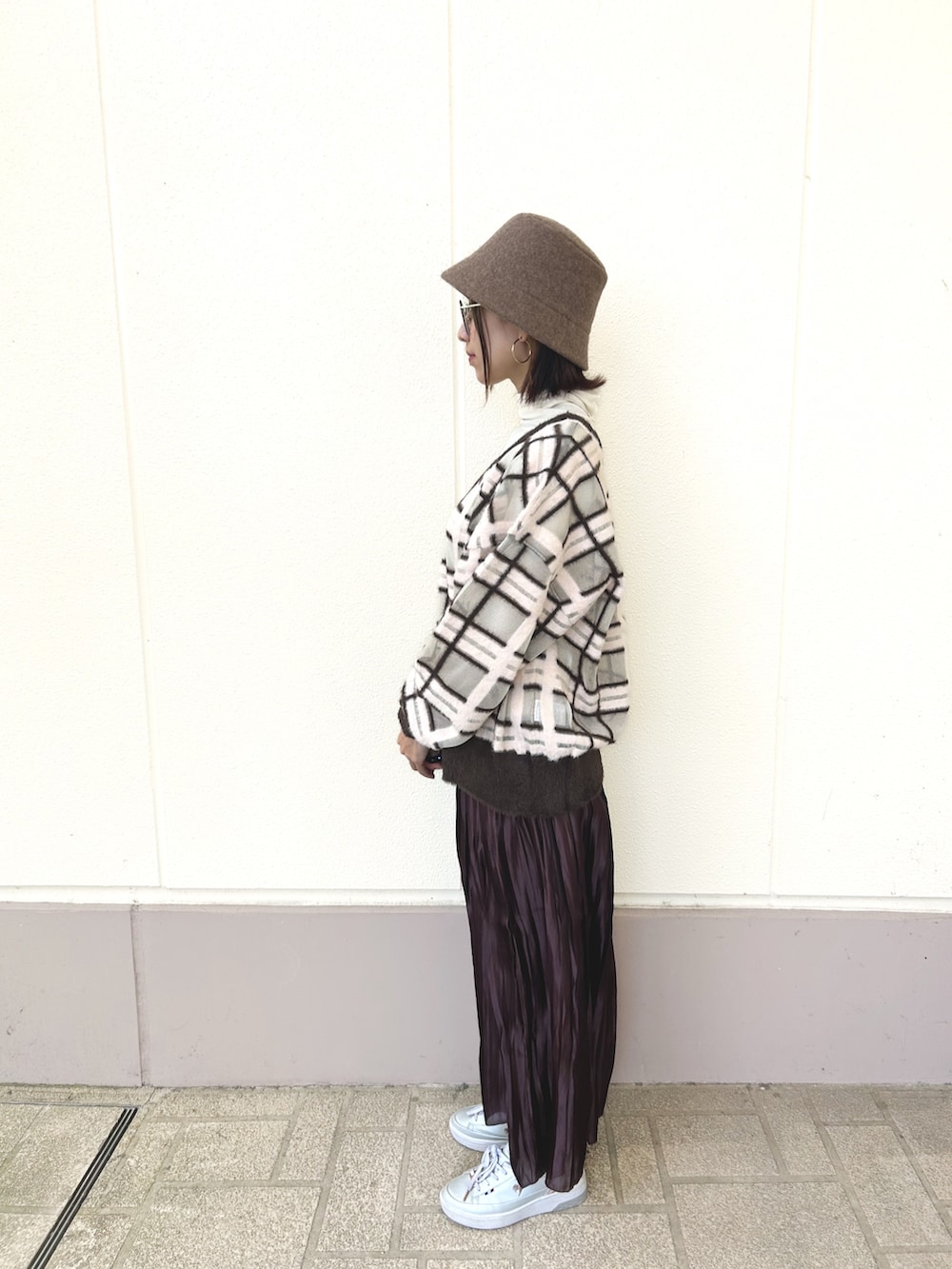 ブラウン系のスカート、ホワイト系のTシャツ/カットソー、その他のニット/セーターを着用したレディースの秋コーディネートの4枚目の写真