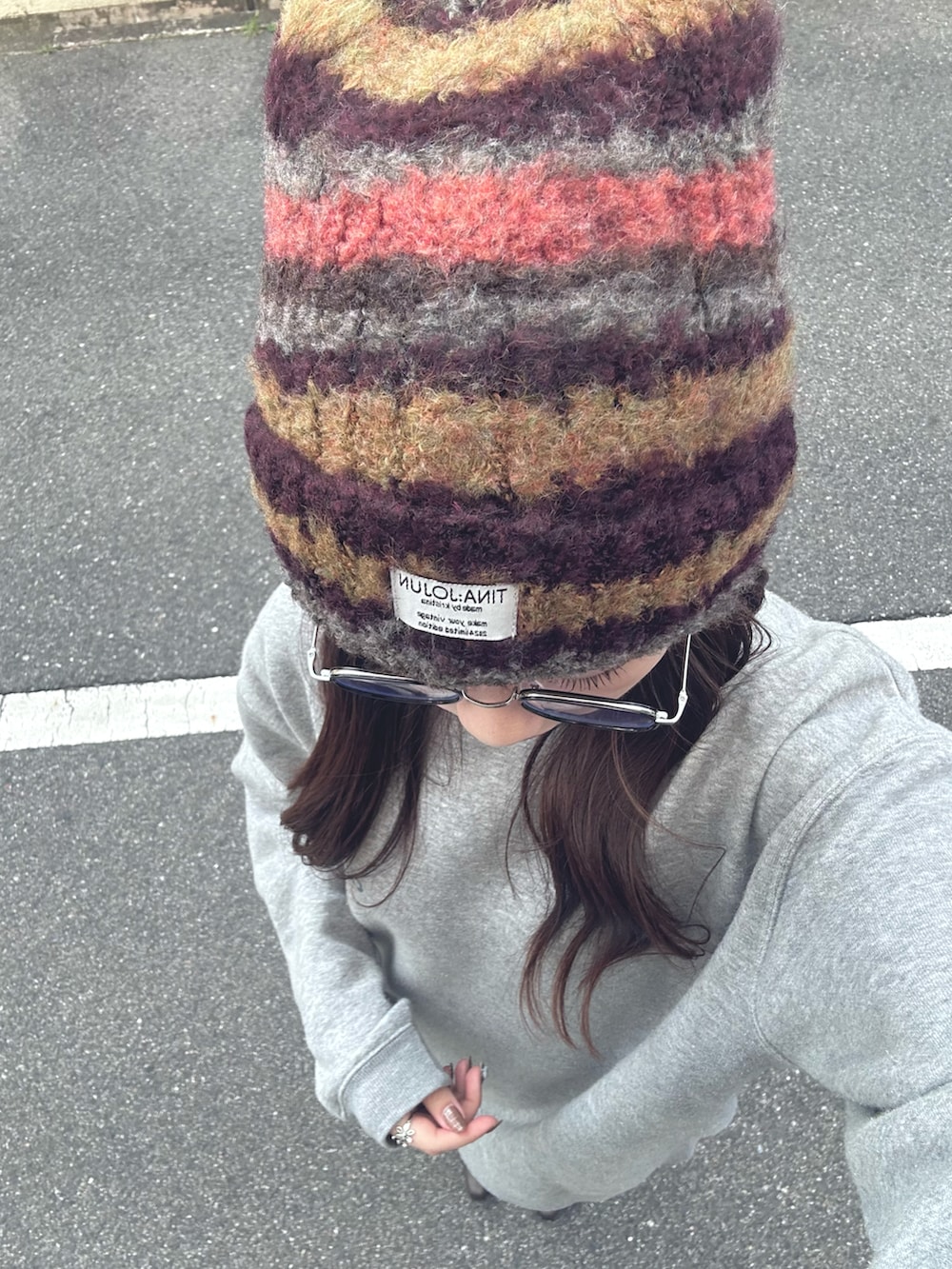 ブラウン系のブーツ、グレー系のスウェット、ブラック系のハンドバッグを着用したレディースの秋コーディネートの2枚目の写真