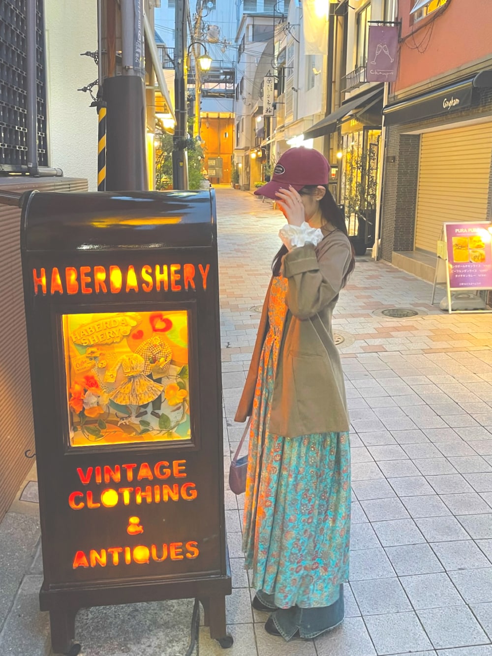 ブラウン系のテーラードジャケット、ブルー系のデニムパンツ、グリーン系のワンピースを着用したレディースの秋コーディネートの4枚目の写真