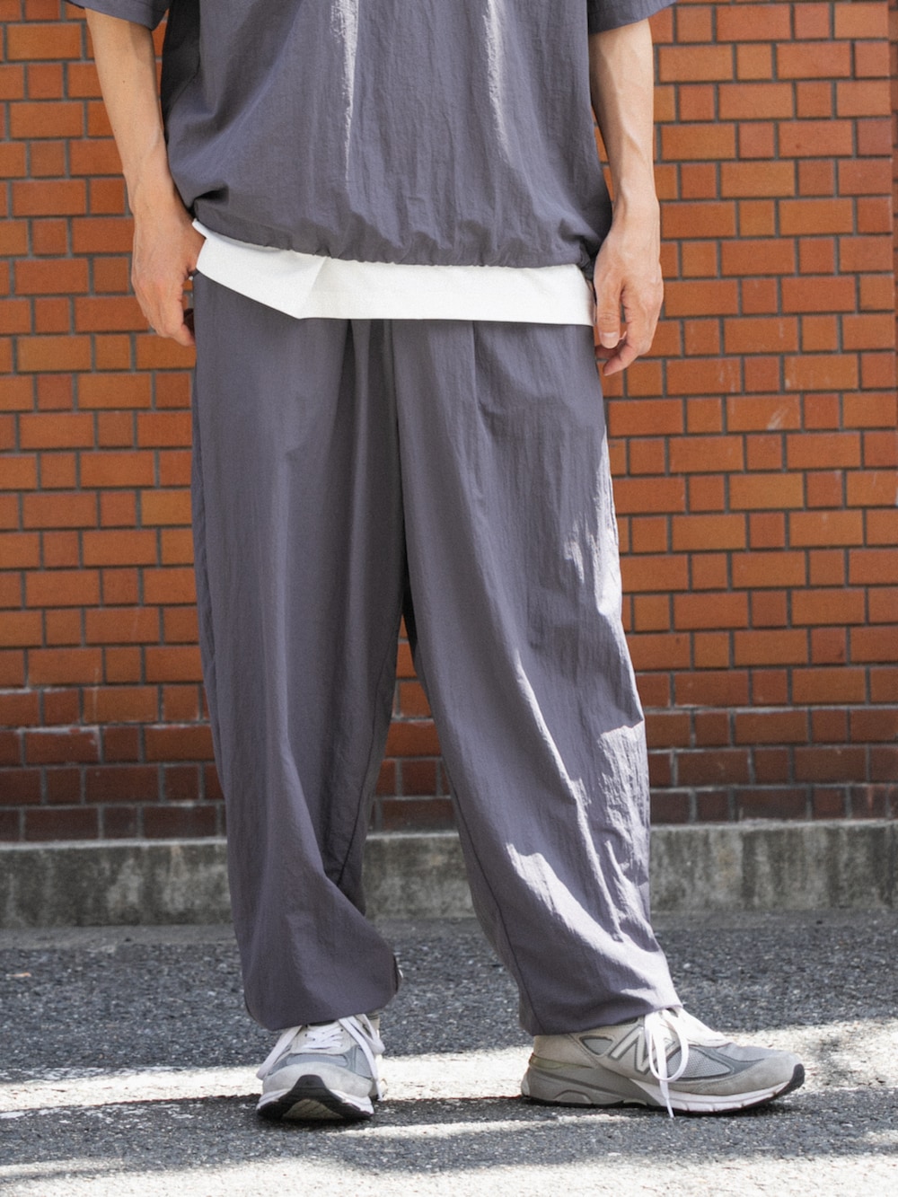 グレー系のTシャツ/カットソー、グレー系のその他パンツを着用したメンズの夏コーディネートの3枚目の写真