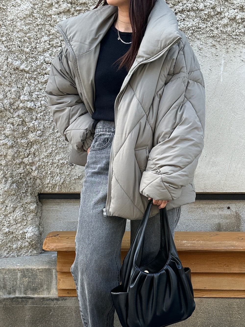 グリーン系のダウンジャケット/コート、ブラック系のハンドバッグ、ブラック系のデニムパンツを着用したレディースの秋コーディネートの5枚目の写真