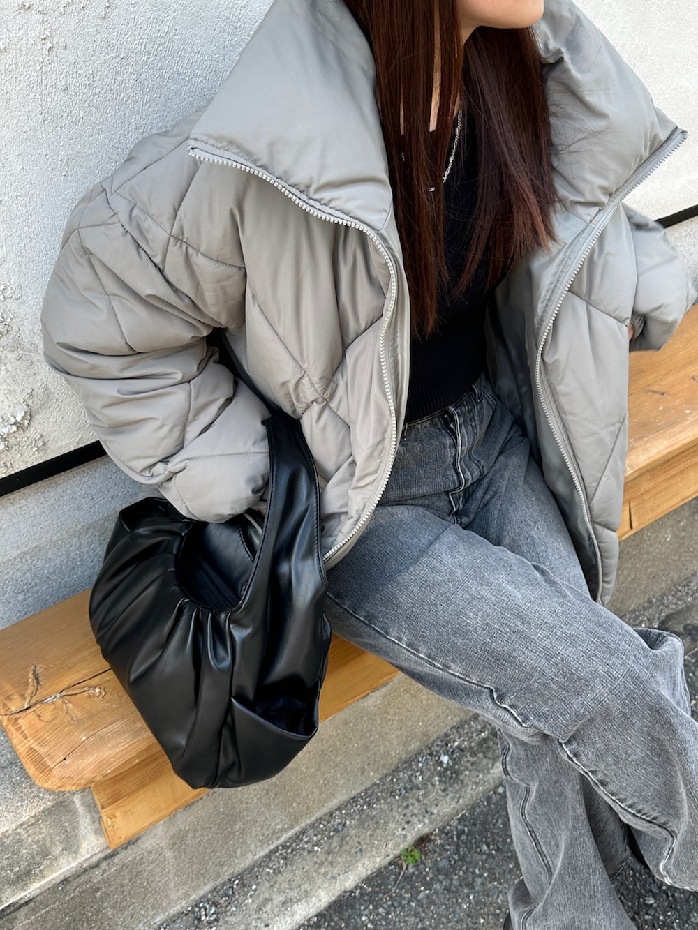 グリーン系のダウンジャケット/コート、ブラック系のハンドバッグ、ブラック系のデニムパンツを着用したレディースの秋コーディネートの2枚目の写真