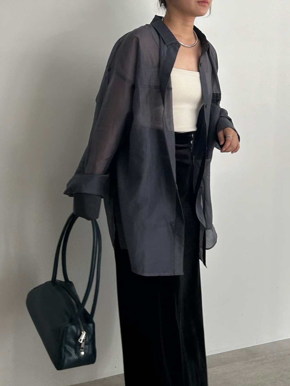 ブラック系のスカート、ブラック系のサンダル、ブルー系のボストンバッグを着用したレディースの春コーディネートの5枚目の写真