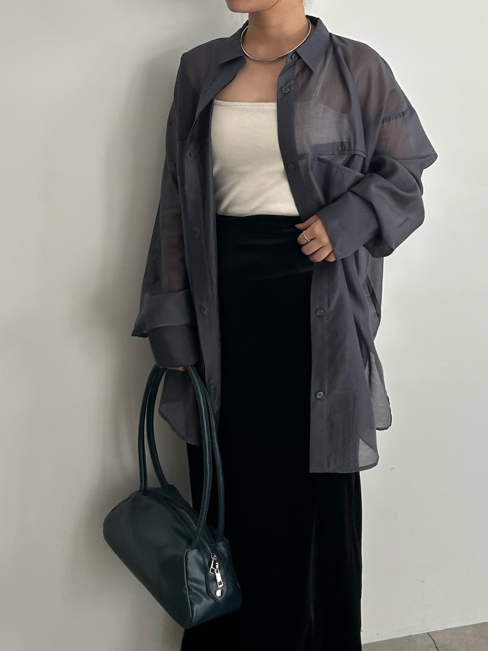 ブラック系のスカート、ブラック系のサンダル、ブルー系のボストンバッグを着用したレディースの春コーディネートの6枚目の写真