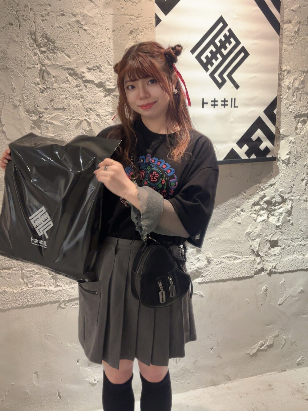 グレー系のスカート、ブラック系のTシャツ/カットソーを着用したレディースの秋コーディネートの2枚目の写真