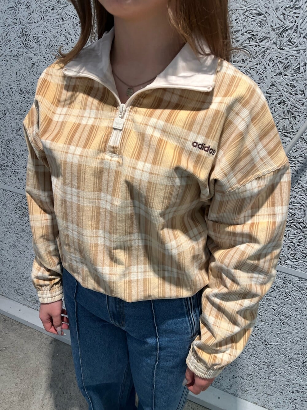 その他のデニムパンツ、ベージュ系のその他トップス、ブラウン系のスニーカーを着用したレディースの冬コーディネートの3枚目の写真