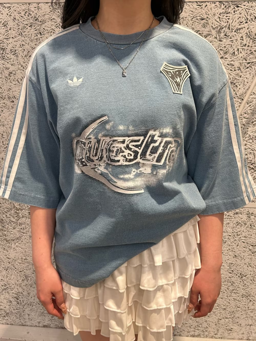 ブラック系のスニーカー、ブルー系のTシャツ/カットソー、ホワイト系のスカートを着用したレディースの春コーディネートの2枚目の写真