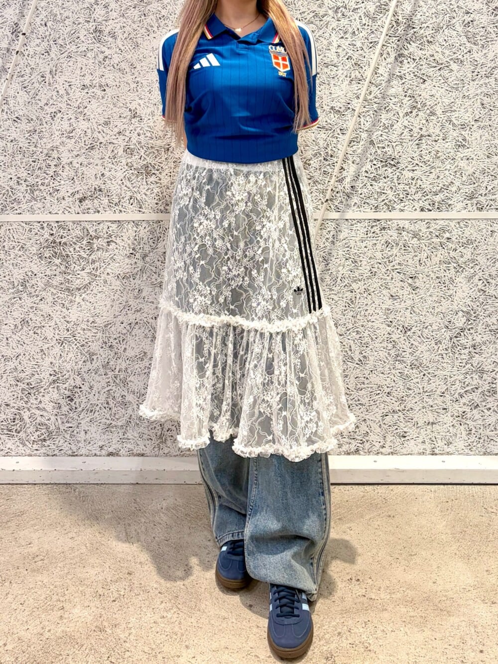 ブルー系のTシャツ/カットソー、ホワイト系のスカート、ブルー系のデニムパンツを着用したレディースの秋コーディネートの2枚目の写真