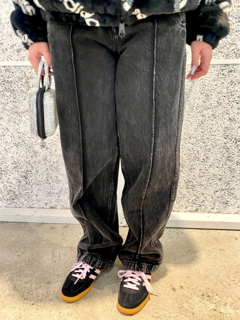 ブラック系のハンドバッグ、ブラック系のブルゾン、ブラック系のデニムパンツを着用したレディースの冬コーディネートの5枚目の写真