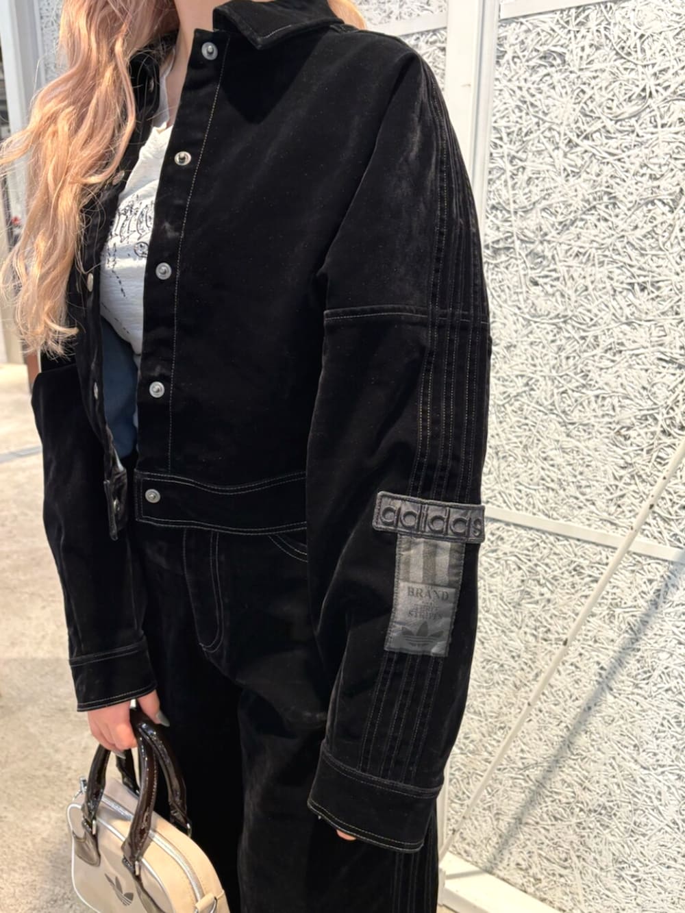 ベージュ系のショルダーバッグ、ブラック系のブルゾン、ブラック系のその他パンツを着用したレディースの秋コーディネートの3枚目の写真