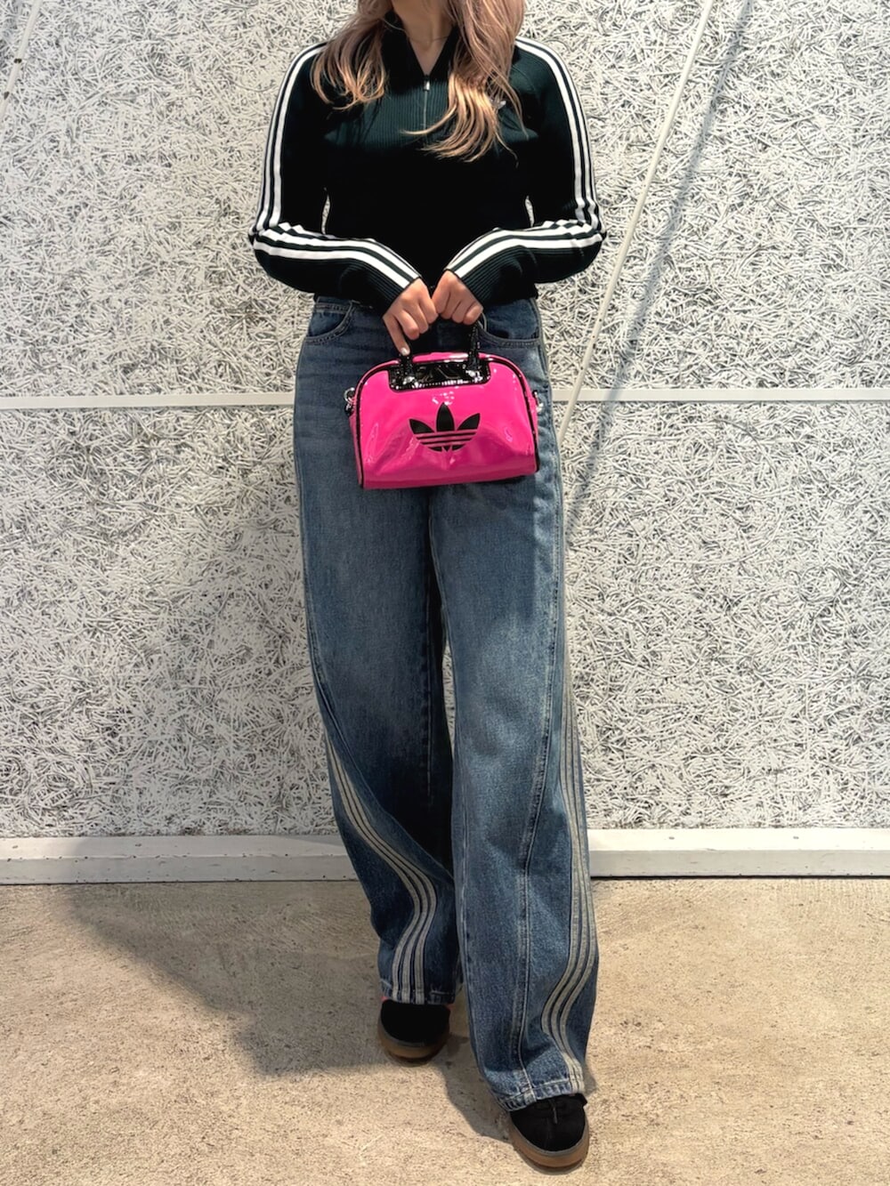 ピンク系のショルダーバッグ、グリーン系のニット/セーター、ブルー系のデニムパンツを着用したレディースの秋コーディネートの2枚目の写真