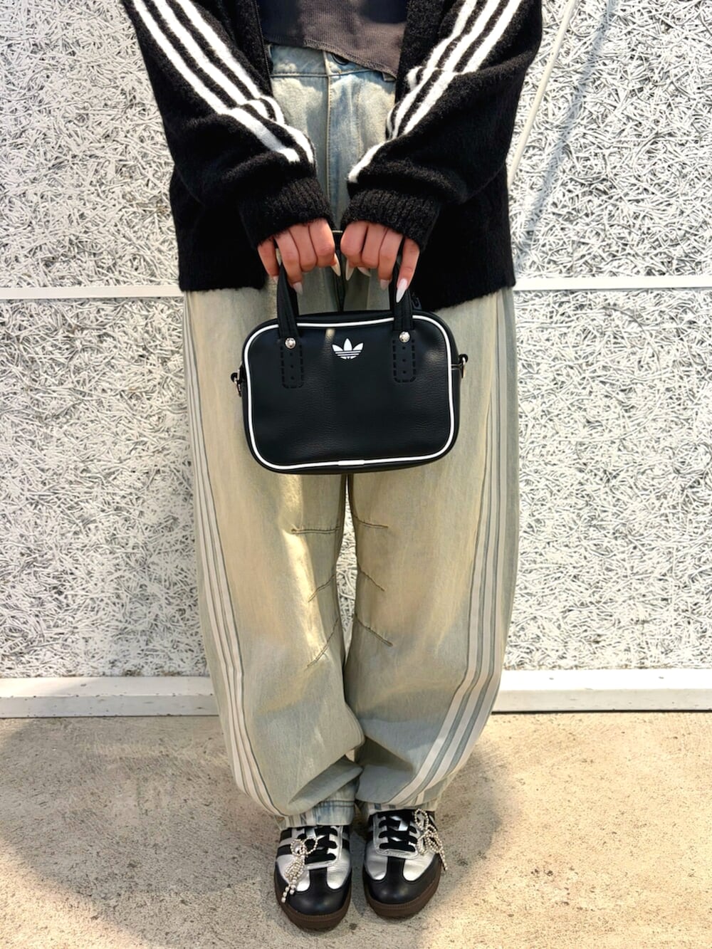 ブラック系のジャージ、ブルー系のデニムパンツ、ブラック系のショルダーバッグを着用したレディースの秋コーディネートの3枚目の写真