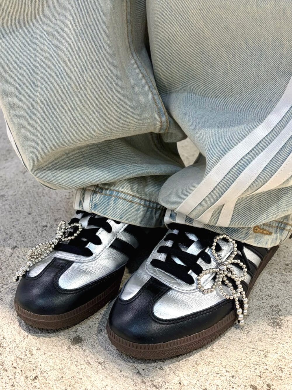 ブラック系のジャージ、ブルー系のデニムパンツ、ブラック系のショルダーバッグを着用したレディースの秋コーディネートの4枚目の写真