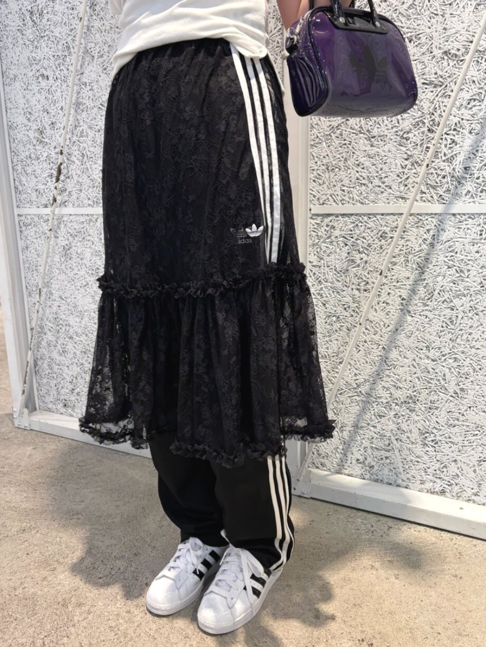 ブラック系のスウェットパンツ、ブラック系のスカート、パープル系のショルダーバッグを着用したレディースの夏コーディネートの2枚目の写真