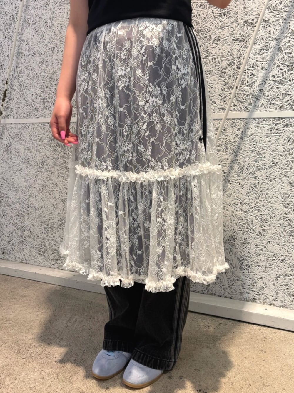 ブラック系のTシャツ/カットソー、ホワイト系のスカート、ブラック系のデニムパンツを着用したレディースの夏コーディネートの4枚目の写真