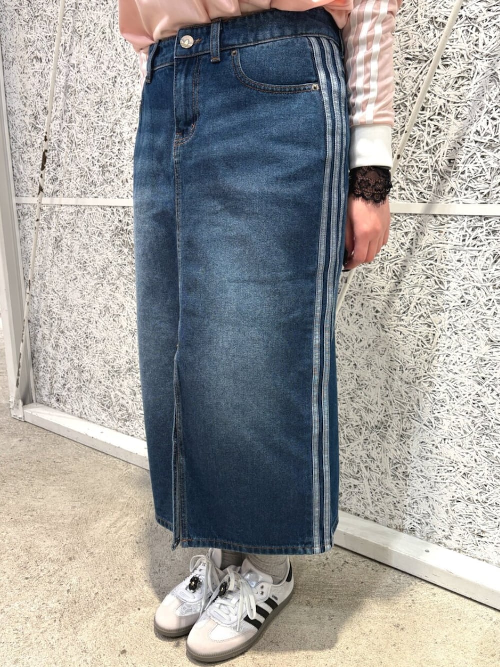 ピンク系のTシャツ/カットソー、ブルー系のデニムスカート、ホワイト系のスニーカーを着用したレディースの春コーディネートの3枚目の写真