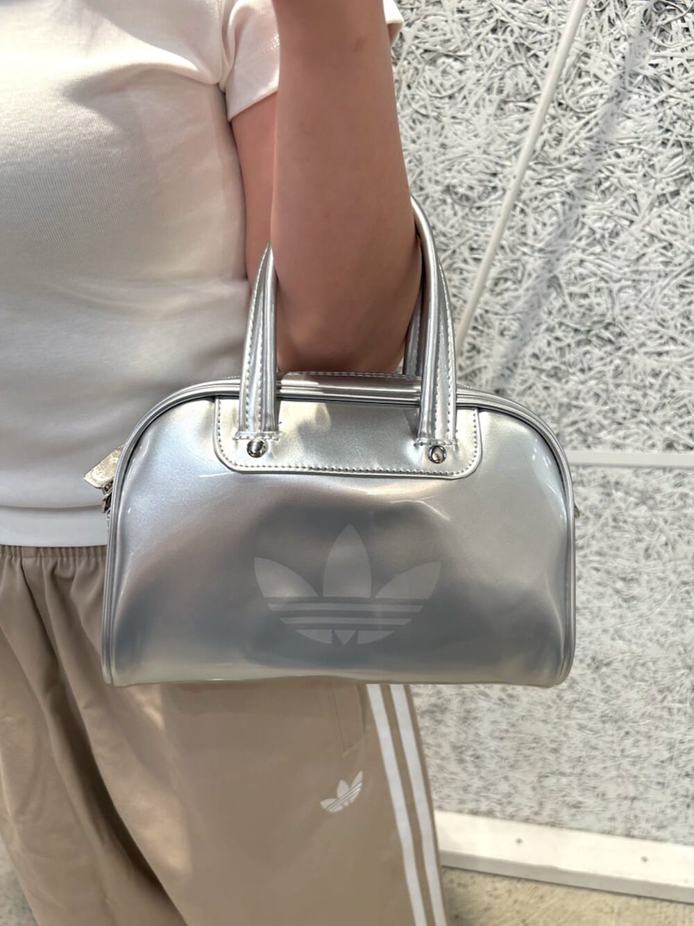 シルバー系のショルダーバッグ、ベージュ系のその他パンツ、シルバー系のスニーカーを着用したレディースの夏コーディネートの3枚目の写真