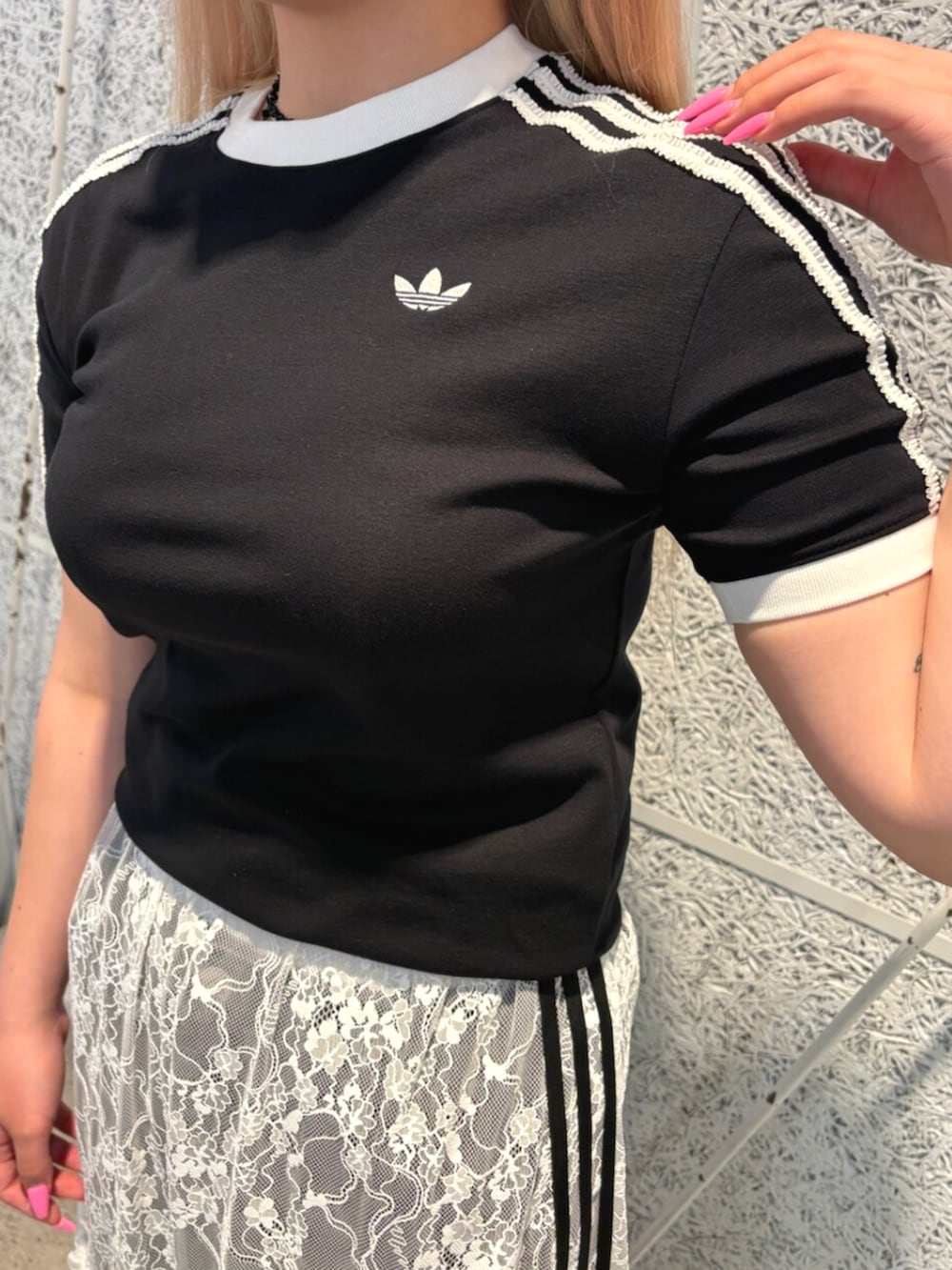 ブラック系のTシャツ/カットソー、ホワイト系のスカート、ブラック系のデニムパンツを着用したレディースの夏コーディネートの3枚目の写真