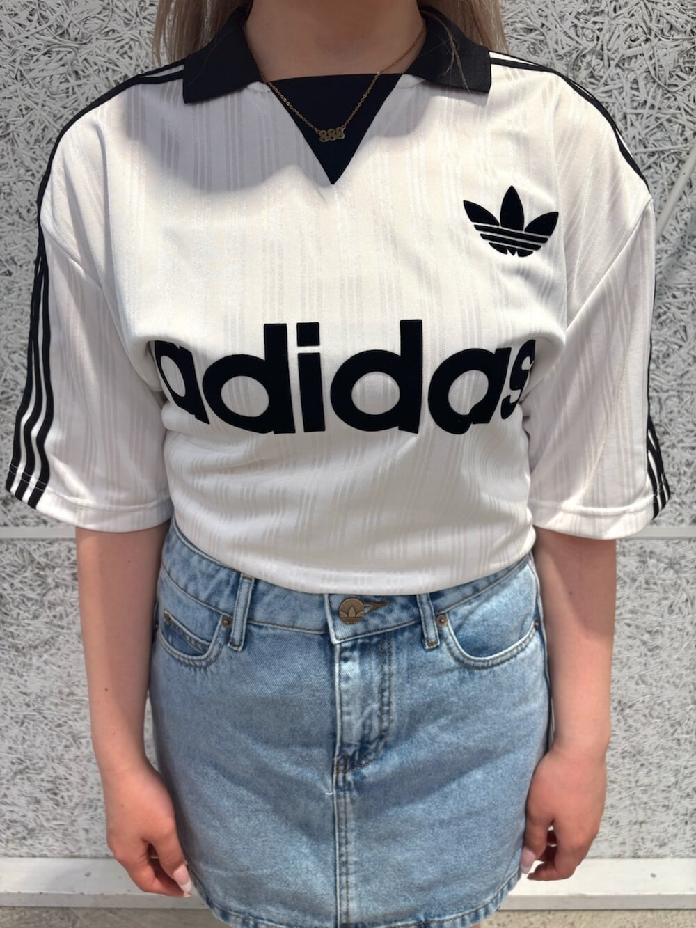 ホワイト系のTシャツ/カットソー、ブルー系のデニムスカート、ホワイト系のシューズを着用したレディースの夏コーディネートの3枚目の写真