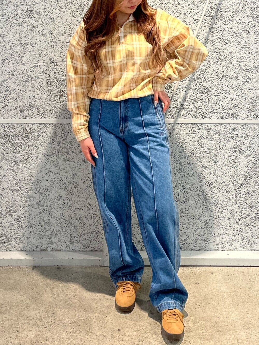 その他のデニムパンツ、ベージュ系のその他トップス、ブラウン系のスニーカーを着用したレディースの冬コーディネートの2枚目の写真