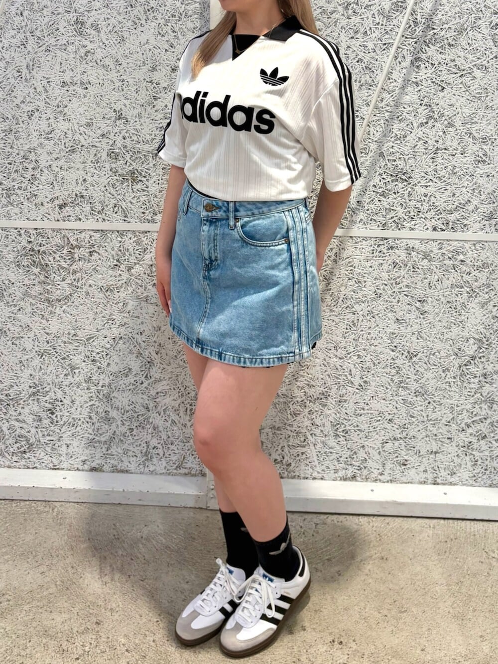 ホワイト系のTシャツ/カットソー、ブルー系のデニムスカート、ホワイト系のシューズを着用したレディースの夏コーディネートの2枚目の写真
