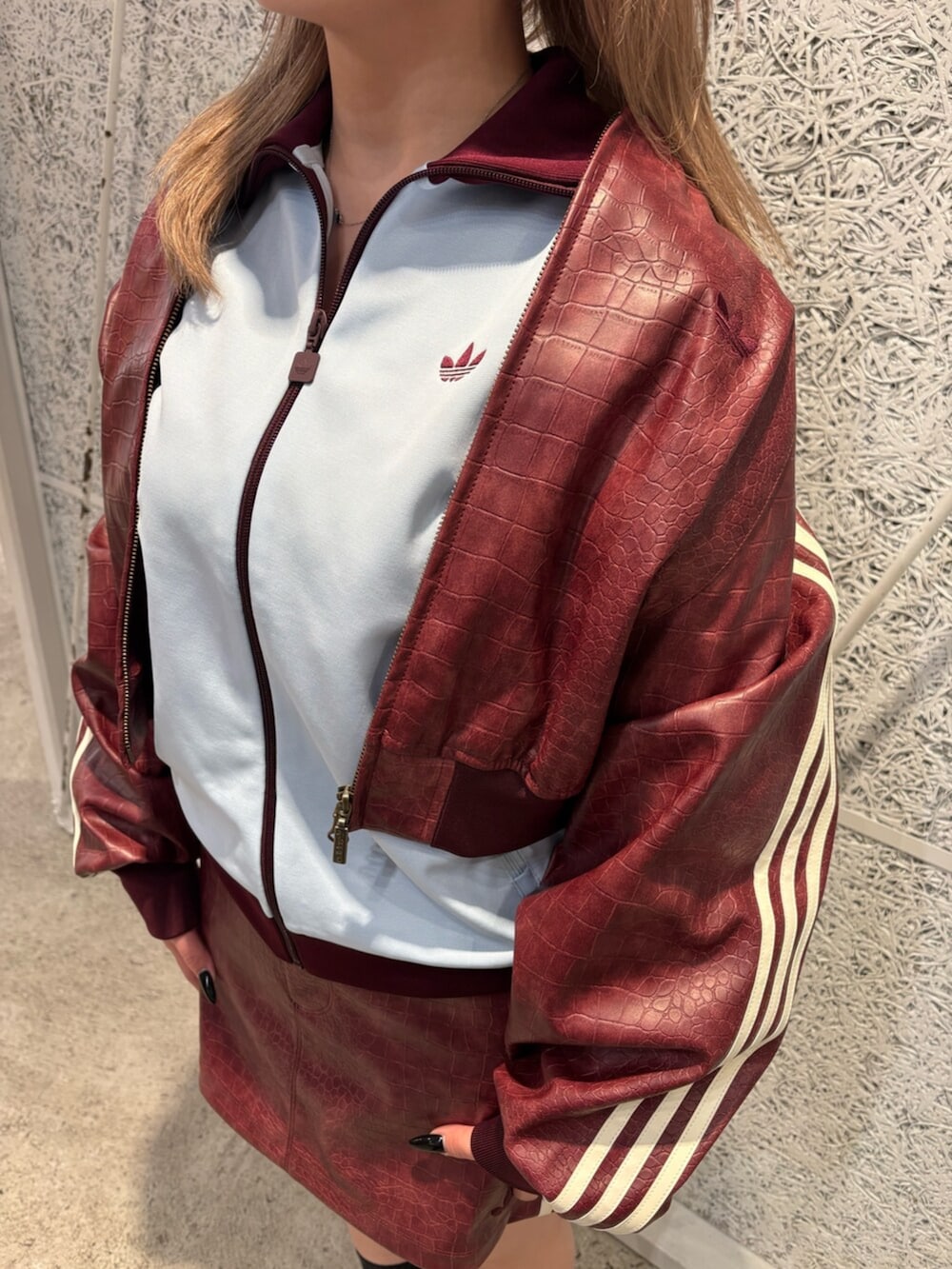 レッド系のスカート、ブルー系のトップス、レッド系のブルゾンを着用したレディースの春コーディネートの2枚目の写真