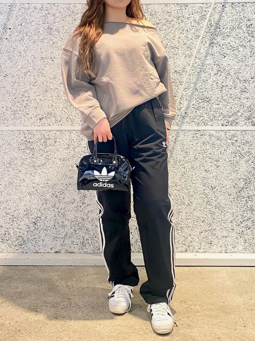 ベージュ系のスウェット、ブラック系のスウェットパンツ、ブラック系のショルダーバッグを着用したレディースの冬コーディネートの2枚目の写真