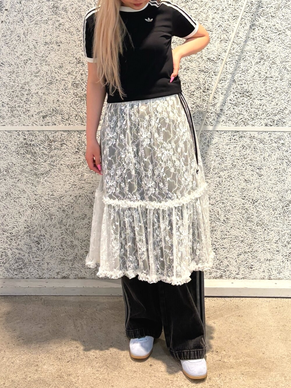 ブラック系のTシャツ/カットソー、ホワイト系のスカート、ブラック系のデニムパンツを着用したレディースの夏コーディネートの2枚目の写真