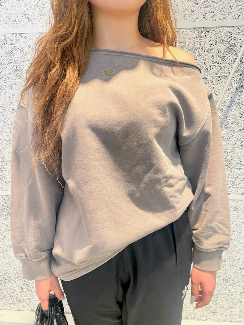 ベージュ系のスウェット、ブラック系のスウェットパンツ、ブラック系のショルダーバッグを着用したレディースの冬コーディネートの3枚目の写真