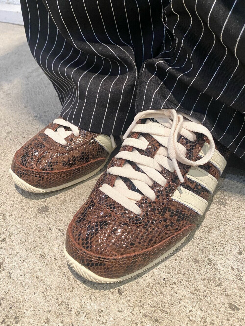 ブラウン系のジャージ、ブラック系のTシャツ/カットソー、ブラウン系のスニーカーを着用したレディースの秋コーディネートの4枚目の写真