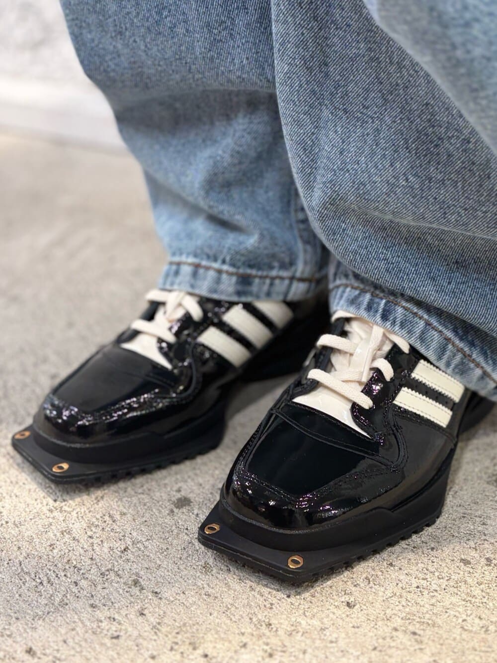 イエロー系のポロシャツ、ブルー系のデニムパンツ、ブラック系のシューズを着用したレディースの夏コーディネートの4枚目の写真
