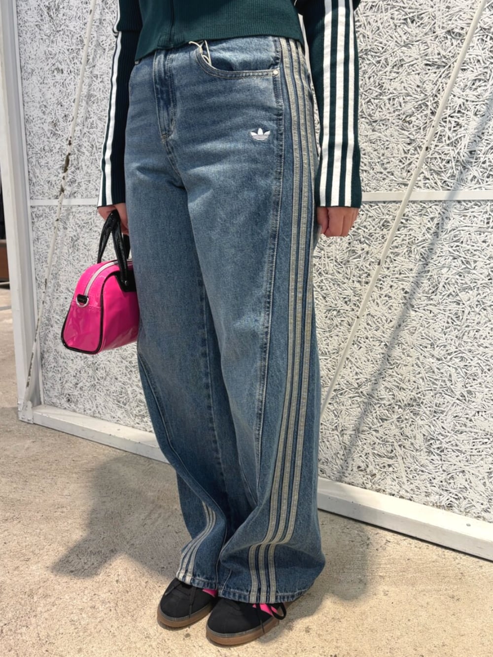 ピンク系のショルダーバッグ、グリーン系のニット/セーター、ブルー系のデニムパンツを着用したレディースの秋コーディネートの4枚目の写真