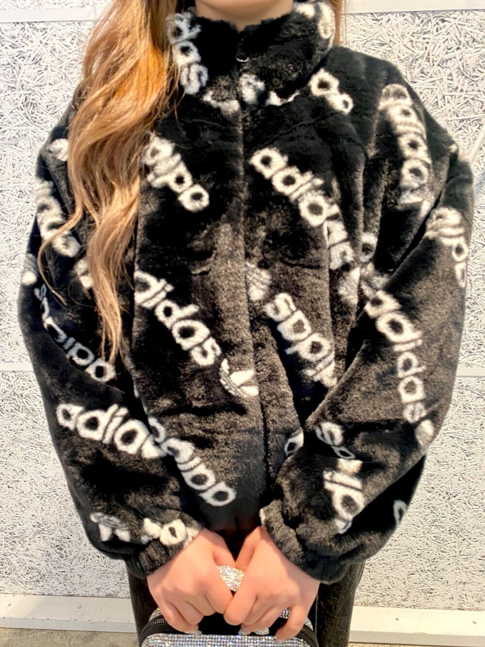 ブラック系のハンドバッグ、ブラック系のブルゾン、ブラック系のデニムパンツを着用したレディースの冬コーディネートの3枚目の写真