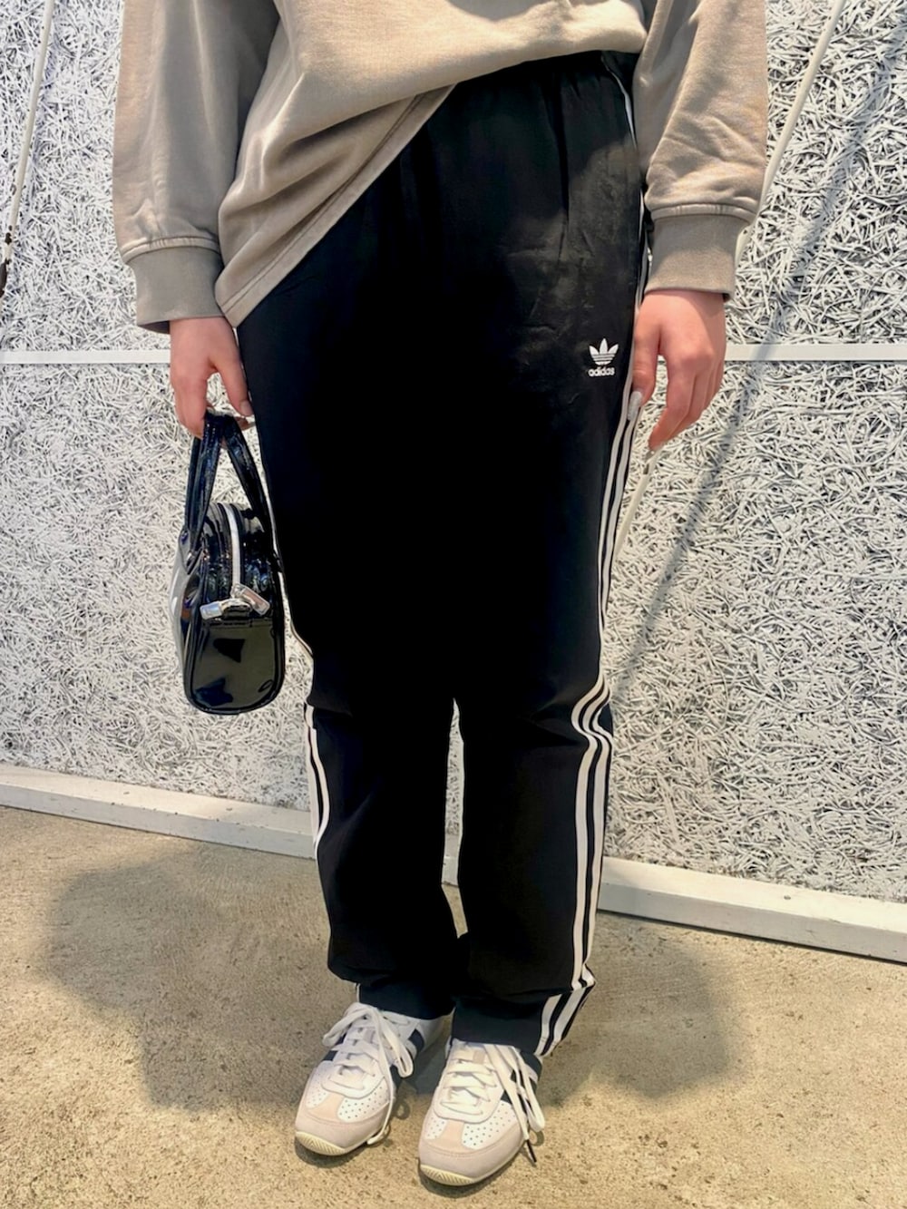 ベージュ系のスウェット、ブラック系のスウェットパンツ、ブラック系のショルダーバッグを着用したレディースの冬コーディネートの4枚目の写真