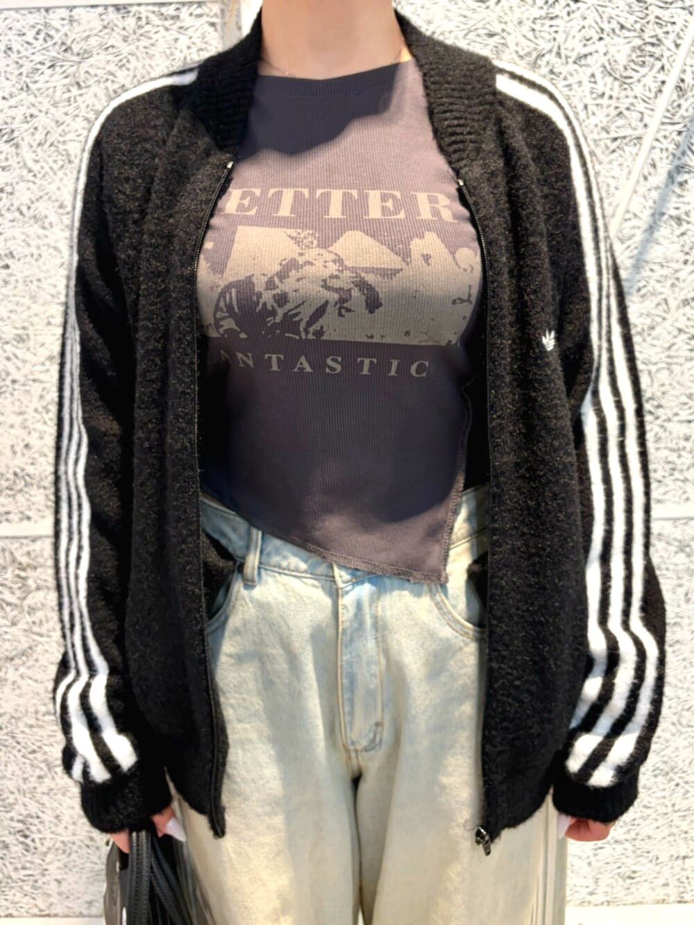 ブラック系のジャージ、ブルー系のデニムパンツ、ブラック系のショルダーバッグを着用したレディースの秋コーディネートの2枚目の写真