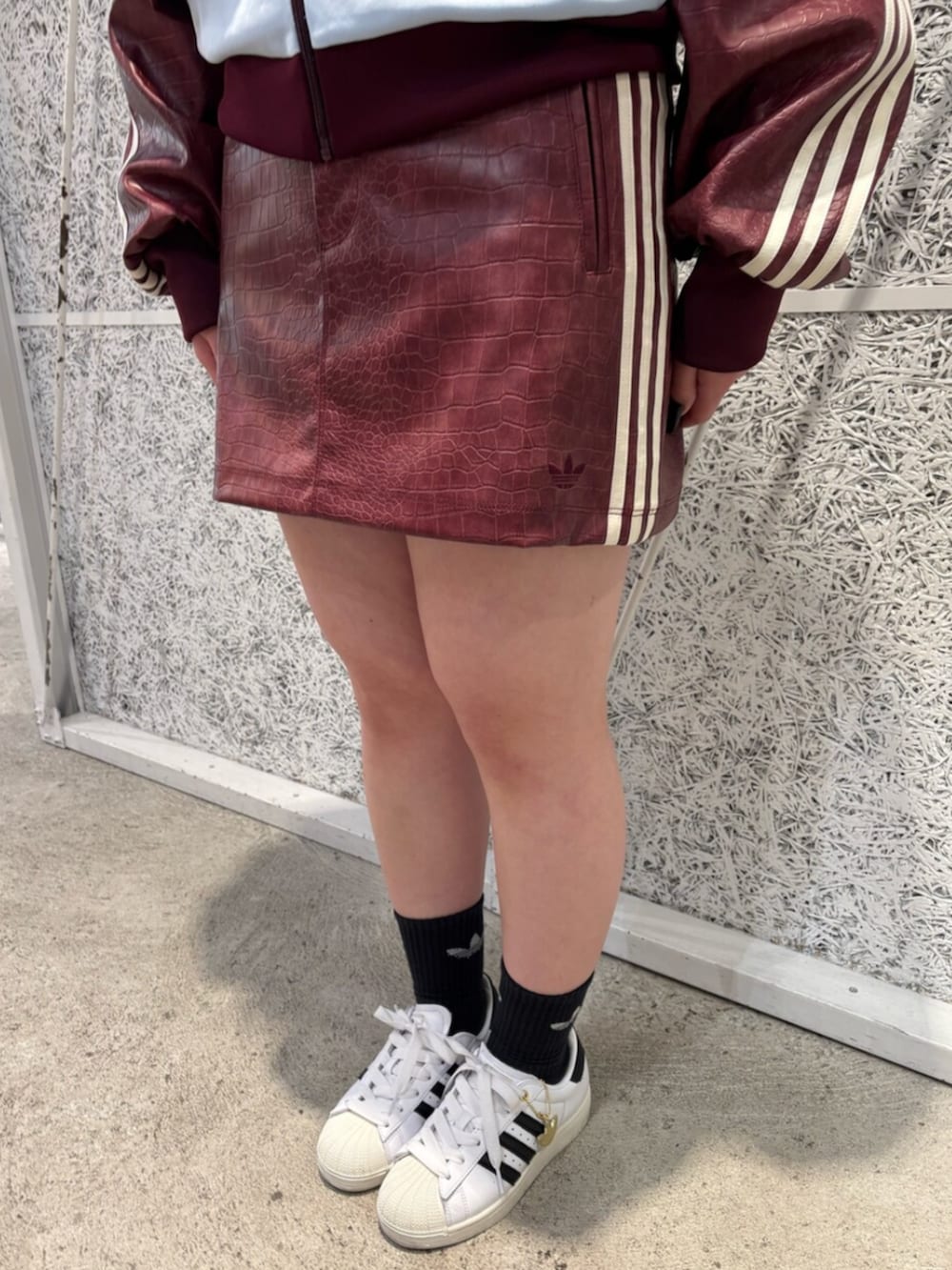 レッド系のスカート、ブルー系のトップス、レッド系のブルゾンを着用したレディースの春コーディネートの3枚目の写真