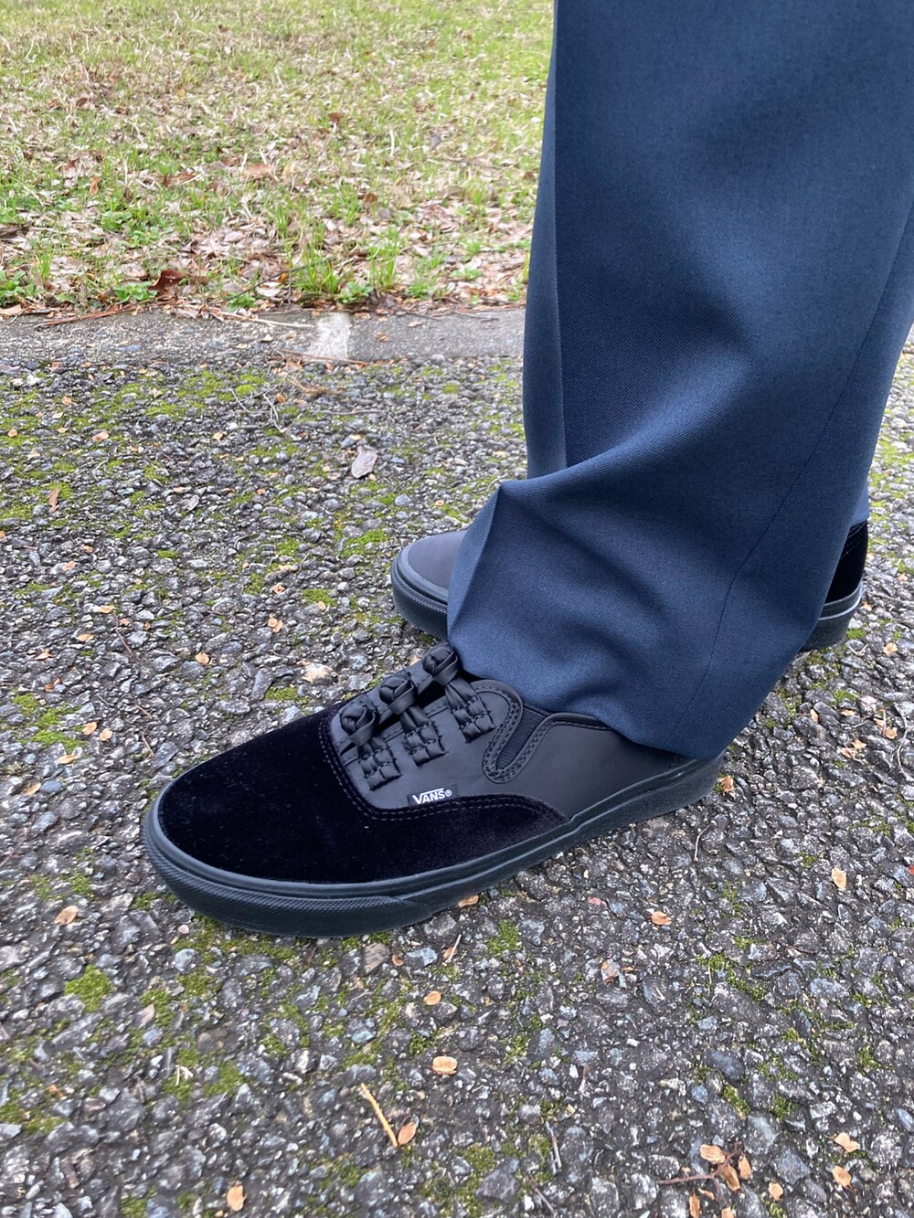 グレー系のブルゾン、ブルー系のスラックス、ブラック系のスニーカーを着用したメンズの冬コーディネートの5枚目の写真