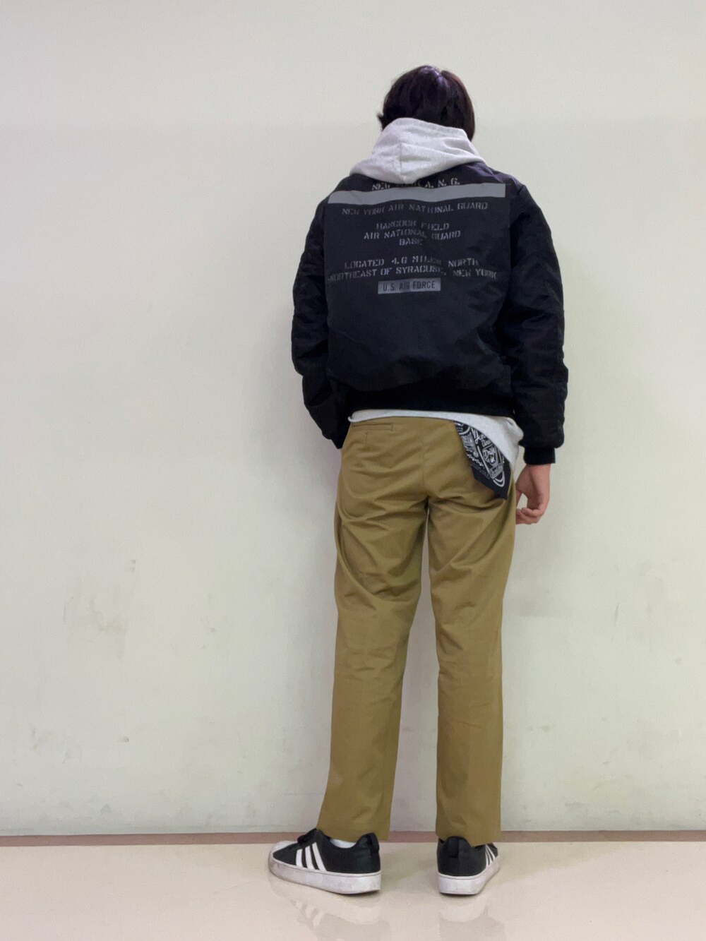 グレー系のパーカー、グリーン系のチノパンツを着用したメンズの夏コーディネートの2枚目の写真