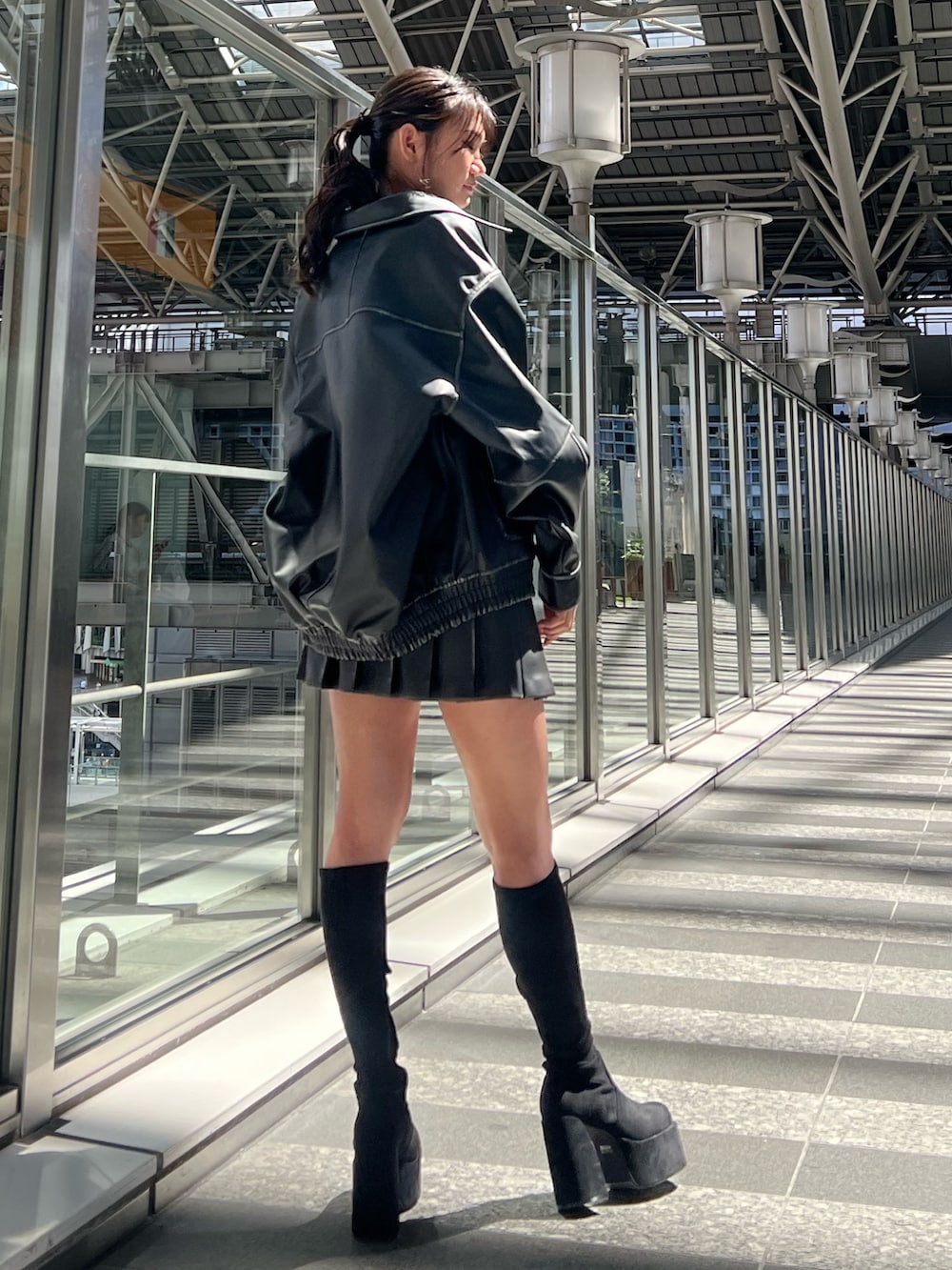 ブラック系のブルゾン、ホワイト系のキャミソール、ブラック系のスカートを着用したレディースの秋コーディネートの3枚目の写真