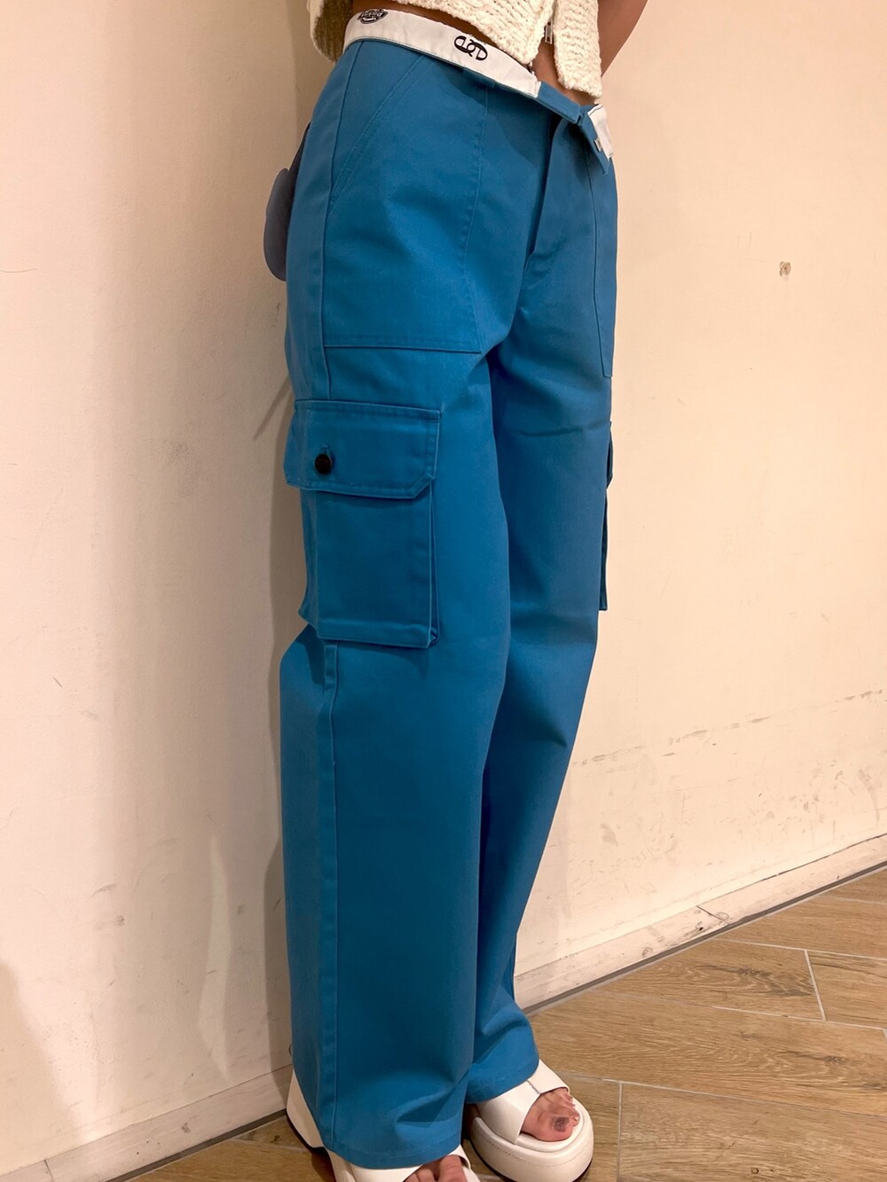 ホワイト系のベスト、ブルー系のカーゴパンツ、ホワイト系のサンダルを着用したレディースの夏コーディネートの6枚目の写真