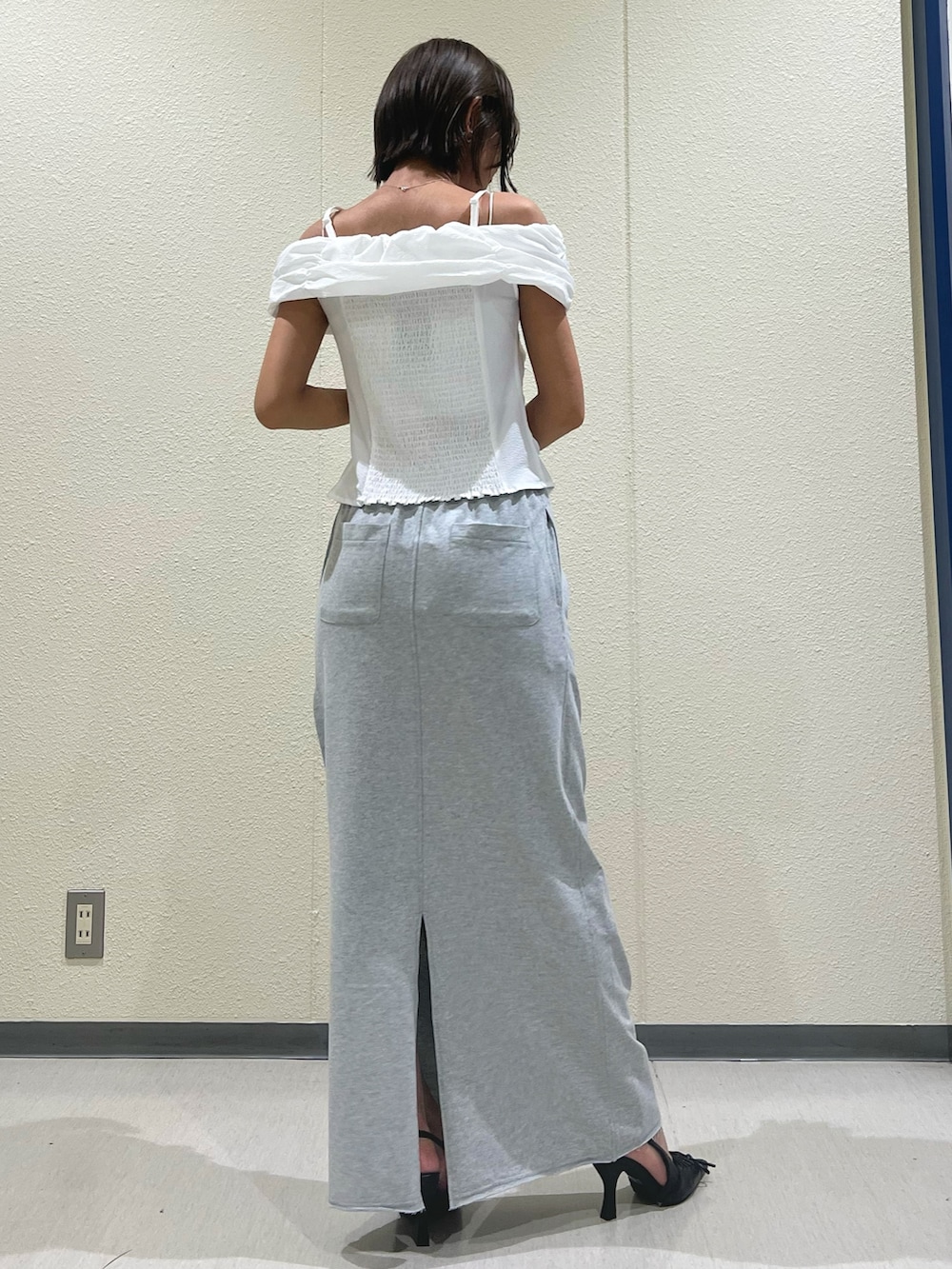 ホワイト系のTシャツ/カットソー、グレー系のスカート、ブラック系のパンプスを着用したレディースの夏コーディネートの3枚目の写真