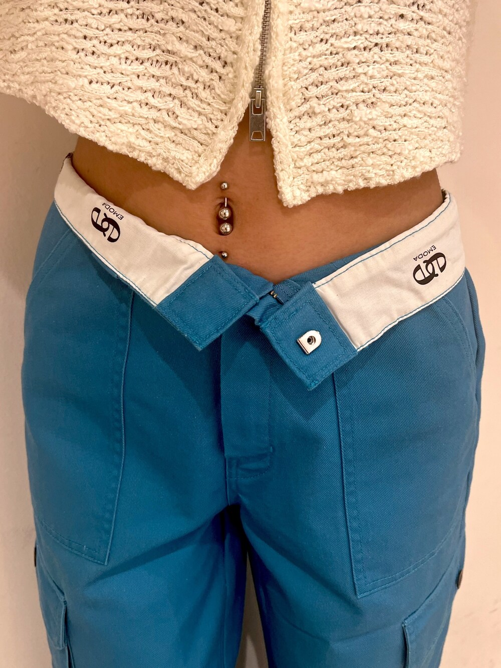 ホワイト系のベスト、ブルー系のカーゴパンツ、ホワイト系のサンダルを着用したレディースの夏コーディネートの5枚目の写真